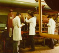 Technicians inspecting compressor installation
